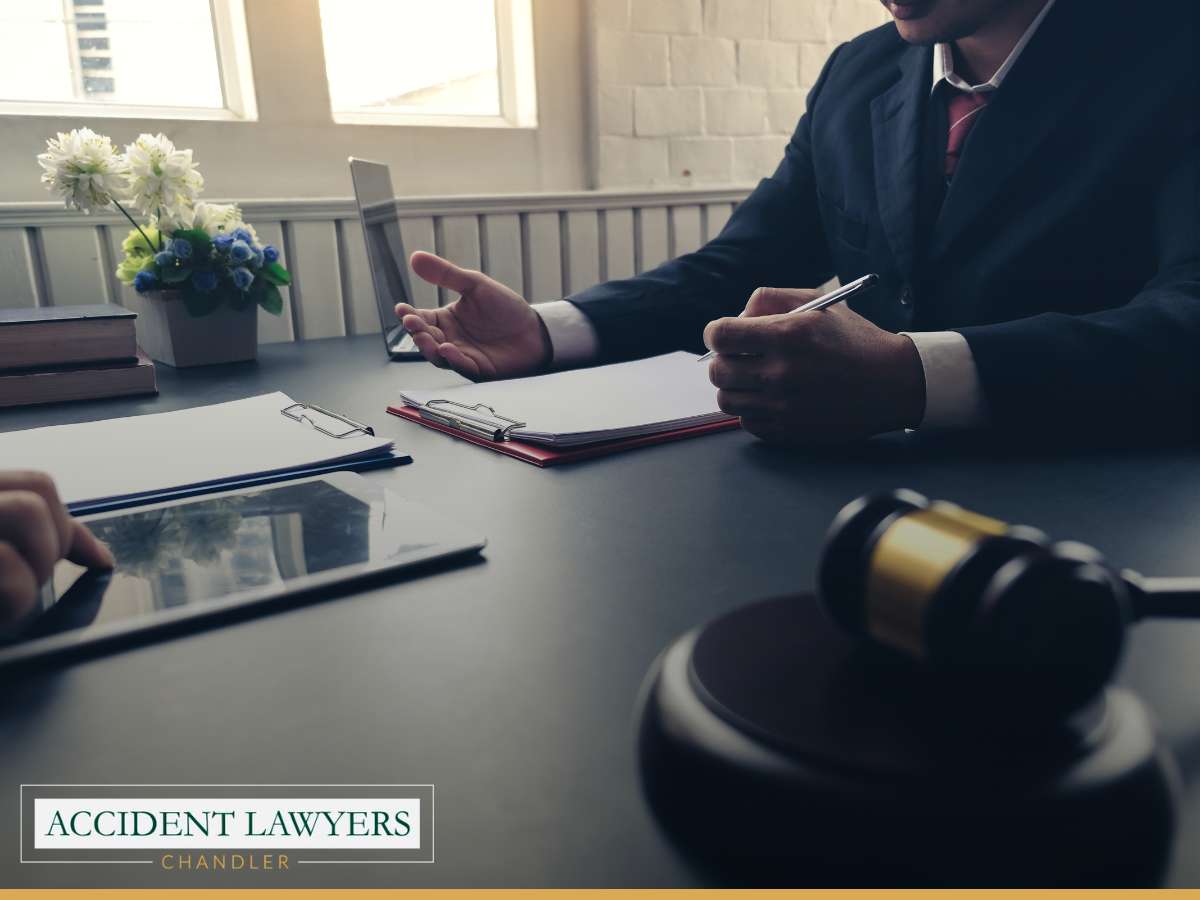A personal injury lawyer advises a client in an office, with a gavel in view, pertinent to motorcycle accident cases in Tempe and Ahwatukee, Arizona